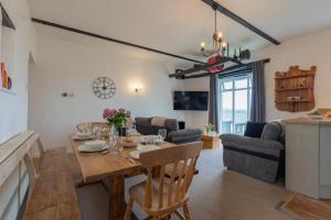 a dining room and living room with a dining table at Duchy - Treworgie Barton Cottages in Bude