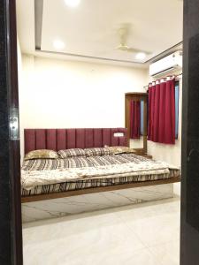 a bed in a room with a red curtain at Hotel shivansh in Godarpura +9 photos