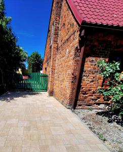ein Backsteingebäude mit rotem Dach und einem Tor in der Unterkunft Gordonówka in Choszczno