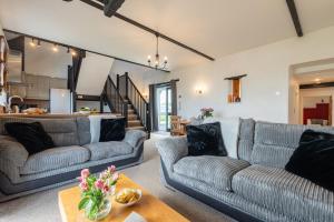 a living room with two couches and a table at Duchy - Treworgie Barton Cottages in Bude