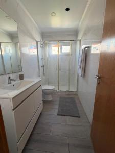 a bathroom with a shower and a sink and a toilet at Estrela de Almada in Almada +44 photos