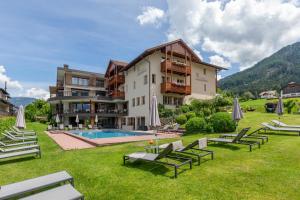ein großes Gebäude mit Pool und Rasenflächen in der Unterkunft Hotel Lindnerhof in St. Lorenzen