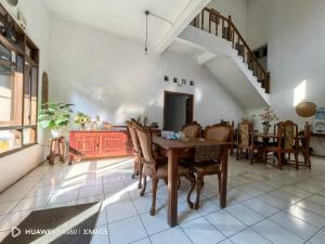 a dining room with a wooden table and chairs at Santalum Hotel Yogyakarta in Yogyakarta