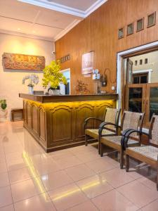 a waiting area with chairs and a counter in a room at Santalum Hotel Yogyakarta in Yogyakarta +28 photos