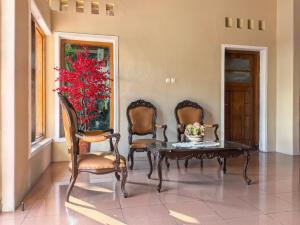 a room with a table and two chairs and a red plant at Santalum Hotel Yogyakarta in Yogyakarta