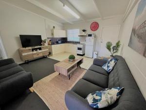 a living room with two couches and a kitchen at Esperance Little Units 3 in Esperance
