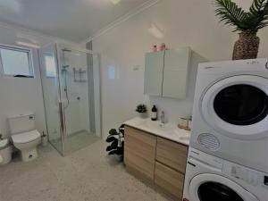 a bathroom with a washing machine in a bathroom at Esperance Little Units 3 in Esperance +6 photos