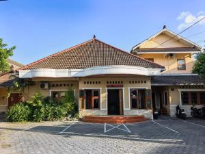 a building with a brick driveway in front of it at Santalum Hotel Yogyakarta in Yogyakarta
