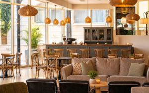 a restaurant with a couch and tables and chairs at Royal Plaza Hotel in Tiberias