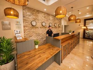 a man standing at a counter in a restaurant at Royal Plaza Hotel in Tiberias +61 photos