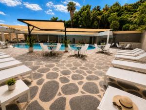 a patio with tables and chairs and a pool at Royal Plaza Hotel in Tiberias