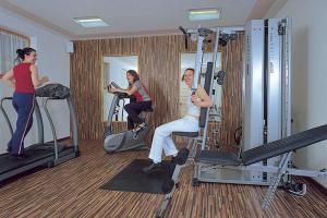 un hombre y dos mujeres ejercitándose en un gimnasio en Hotel San Leonardo, en Badia
