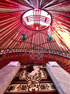 a room with two beds in a red tent at Nomad Garden Camp in Cholpon-Ata