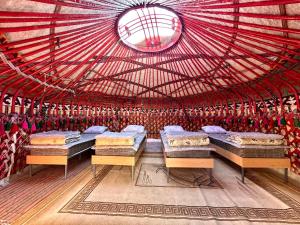 a room with three beds in a yurt at Nomad Garden Camp in Cholpon-Ata