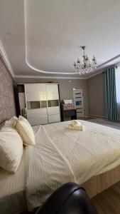 a bedroom with a large white bed with a chandelier at Eneshka- дача in Dolinka