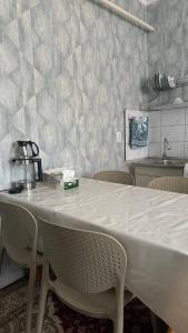 a white table with chairs in a room at Eneshka- дача in Dolinka