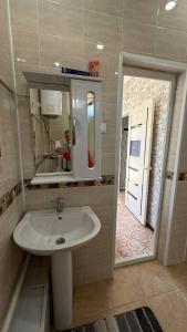 a bathroom with a white sink and a mirror at Eneshka- дача in Dolinka +5 photos
