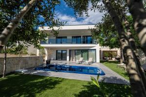 a house with a swimming pool in a yard at Vila Marila in Stara Novalja