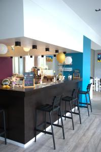 a bar with black chairs at a restaurant at HI Hostel Dunepanne in De Haan