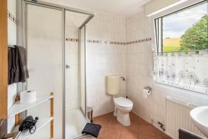 a bathroom with a toilet and a sink and a window at Haus Hermes in Kirchhundem +62 photos