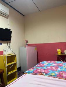 a room with a bed and a refrigerator at ชมภูนุช ห้องพัก เกาะล้าน in Ko Larn