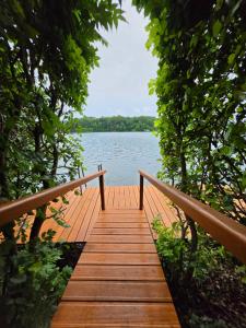 a wooden bridge over a body of water at Landhaus am See - Gästezimmer in Strausberg