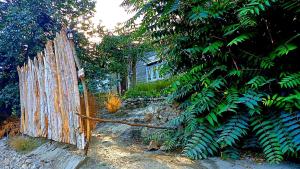 an old wooden gate in front of a tree at Cottage De Hunza- A Soul Retreat Sanctuary in Hunza Valley