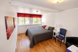a bedroom with a bed and a chair and a window at Husby Wärdshus in Dala Husby
