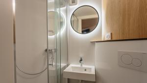 a bathroom with a shower and a sink and a mirror at Premiere Classe Biarritz in Biarritz +37 photos