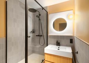 a bathroom with a shower and a sink and a mirror at Limehome Munich Fritz-Erler Str in Munich +61 photos