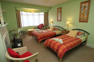 a hotel room with two beds and a couch at Cranston House in East Grinstead