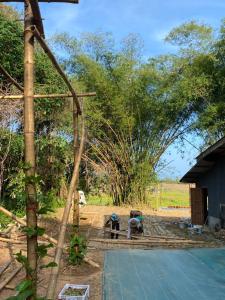 a person sitting on a bench in a field at Laena Homestay in Ko Yao Noi