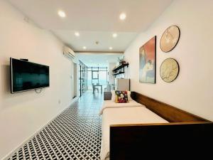 a living room with a couch and a tv on a wall at Nomad Apartment in Nha Trang