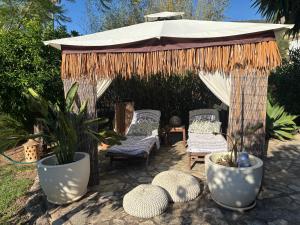 a gazebo with chairs and plants in a yard at Casita Limón Andratx in Andratx