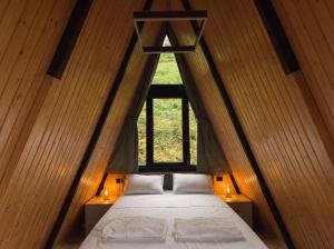 a bed in a wooden room with a window at Villa MERISI in Merisi +14 photos