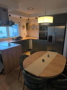 a kitchen with a wooden table and chairs in it at Ema & Jakov in Sreser