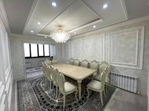 a dining room with a table and chairs and a chandelier at Квартира in Samarkand