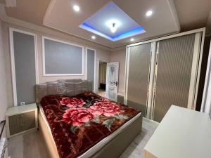 a bedroom with a large bed with pink roses on it at Квартира in Samarkand