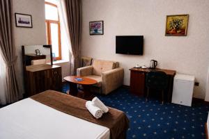 a hotel room with a bed and a chair and a television at Porto Bistro in Baku