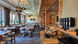 a restaurant with wooden tables and stools at Hotel Dahoam by Miha in Westendorf