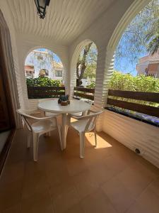 a white table and two chairs on a porch at Casa en la playa con piscinas in Gran Alacant