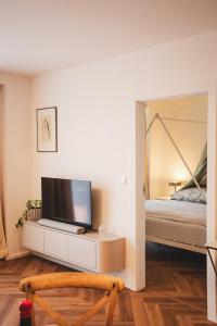 a bedroom with a bed and a television on a dresser at Pioneer house - app with free parking place, terrace and private garden in Koliba