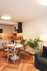 a living room with a table and chairs and a kitchen at Pioneer house - app with free parking place, terrace and private garden in Koliba