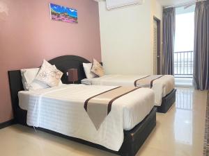 two beds in a hotel room with at Leelawadee Modern Resort Huaykwang - ลีลาวดี ห้วยขวาง in Bangkok