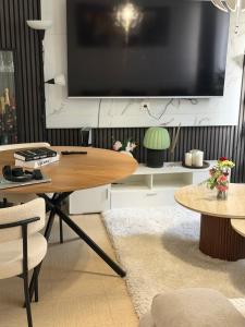 a living room with a large television on a wall at Faith hot in Courcouronnes