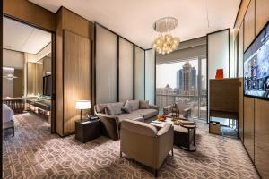 a living room with a couch and a tv at Narcissus The Royal Hotel in Riyadh