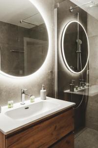 a bathroom with a sink and a large mirror at Pioneer house - app with free parking place, terrace and private garden in Koliba +20 photos