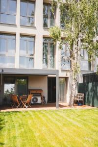 a house with a lawn in front of a building at Pioneer house - app with free parking place, terrace and private garden in Koliba