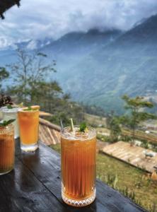 three drinks sitting on a wooden table with a view at Lagom home - Cactus in Sapa