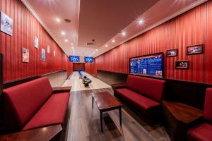 a bowling alley with red walls and a little boy sitting in it at Hotel Lidia - część Economy in Darłowo +3 photos